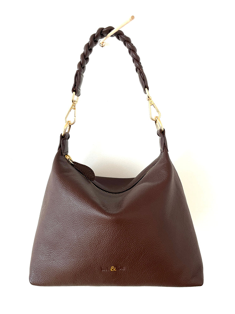Brown handbag with braided handle on a white background