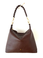 Brown handbag with braided handle on a white background