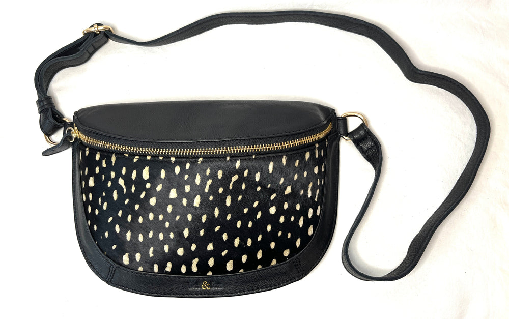 Black crossbody bag with gold accents on a white background