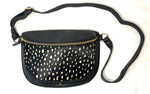 Black crossbody bag with gold accents on a white background